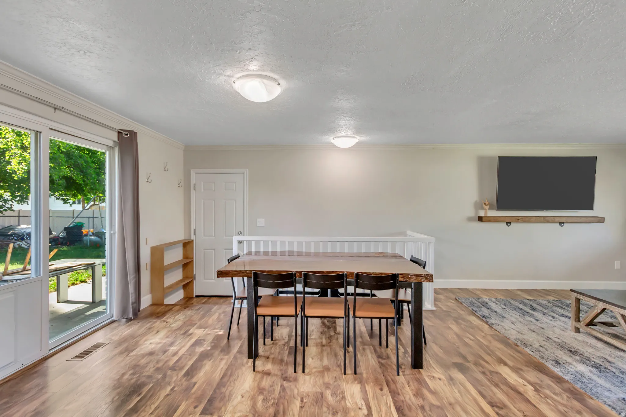 Spacious room featuring wood-finish flooring, a white trim package, and two ceiling-mounted light fixtures
