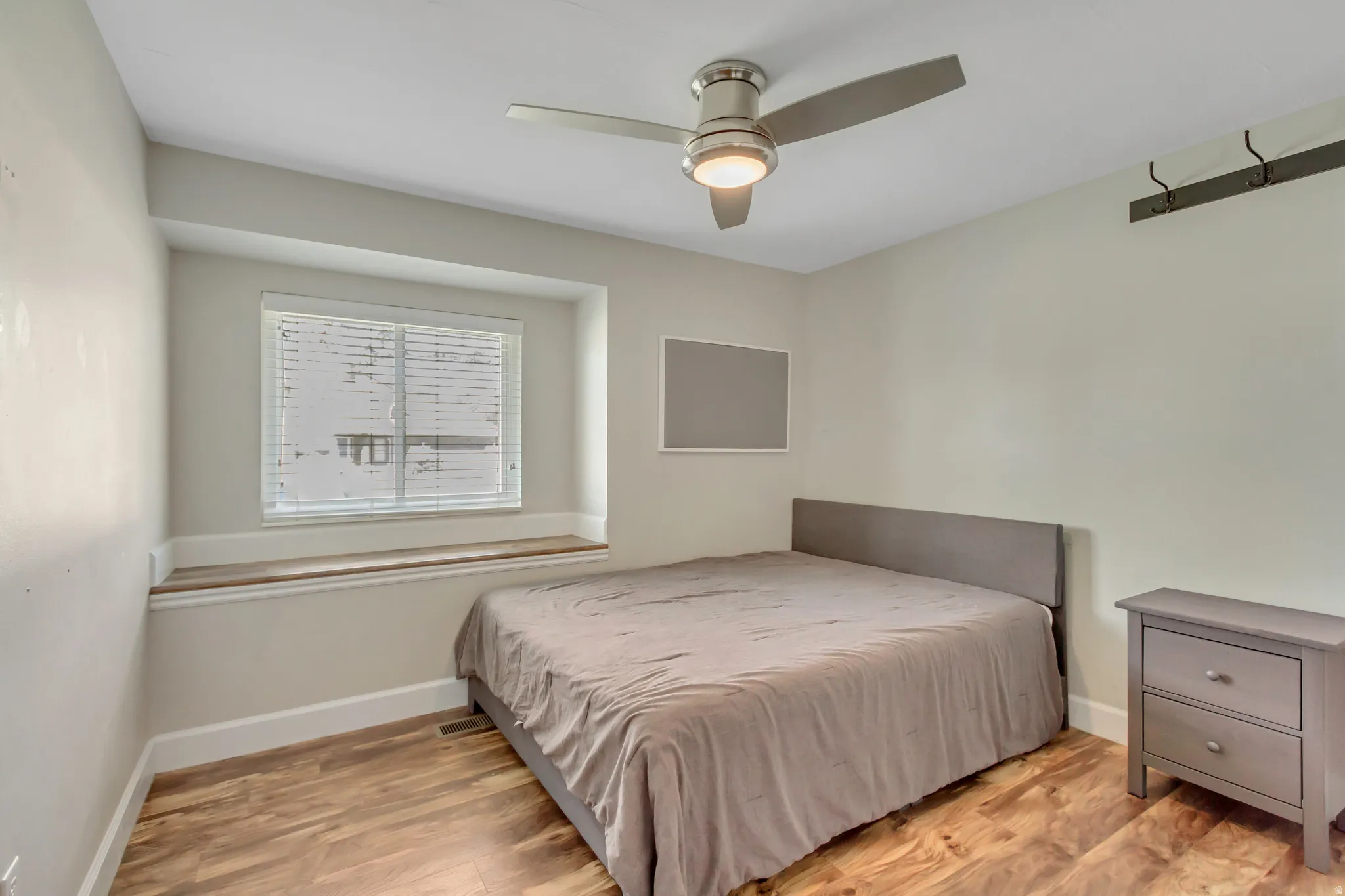 Room featuring wood-finish flooring and a built-in window seat with a wood surface