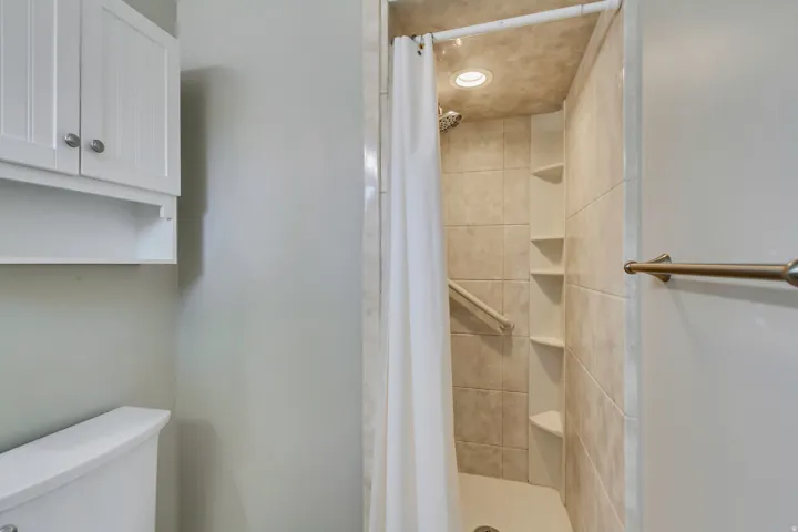 Tiled walk-in shower with a recessed light fixture and integrated corner shelving