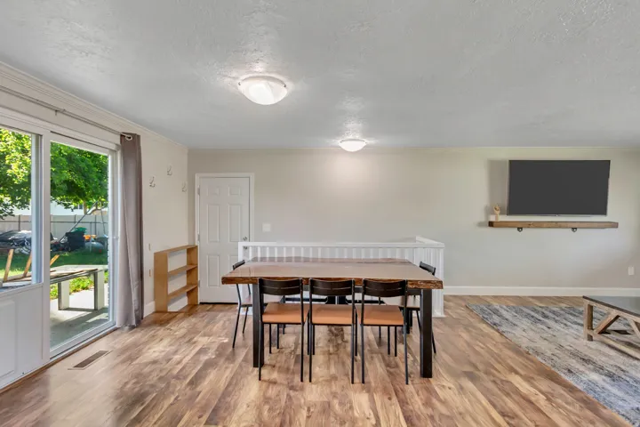 Spacious room featuring wood-finish flooring, a white trim package, and two ceiling-mounted light fixtures