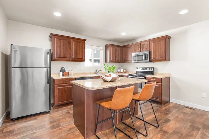 Kitchen featuring wood-finish flooring, recessed lighting, and a central island with a granite-style countertop