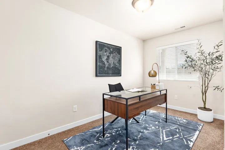 Carpeted room with neutral wall paint and a single window featuring horizontal blinds