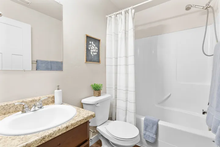 Contemporary bathroom featuring a vanity with a stone-look countertop, undermount sink, and chrome faucet