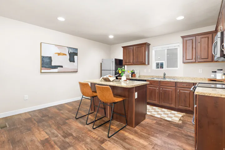 Kitchen featuring wood-finish flooring, recessed lighting, and a center island with a granite-style countertop