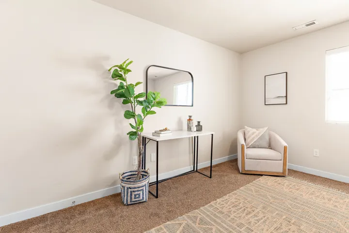 Neutral painted walls with white trim, brown carpet flooring, and a window providing natural illumination