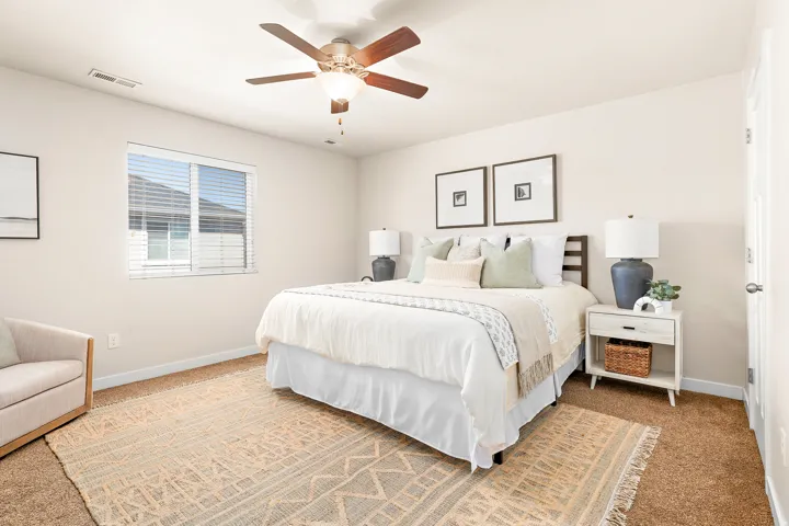 Bedroom with neutral wall color and complementing carpet flooring