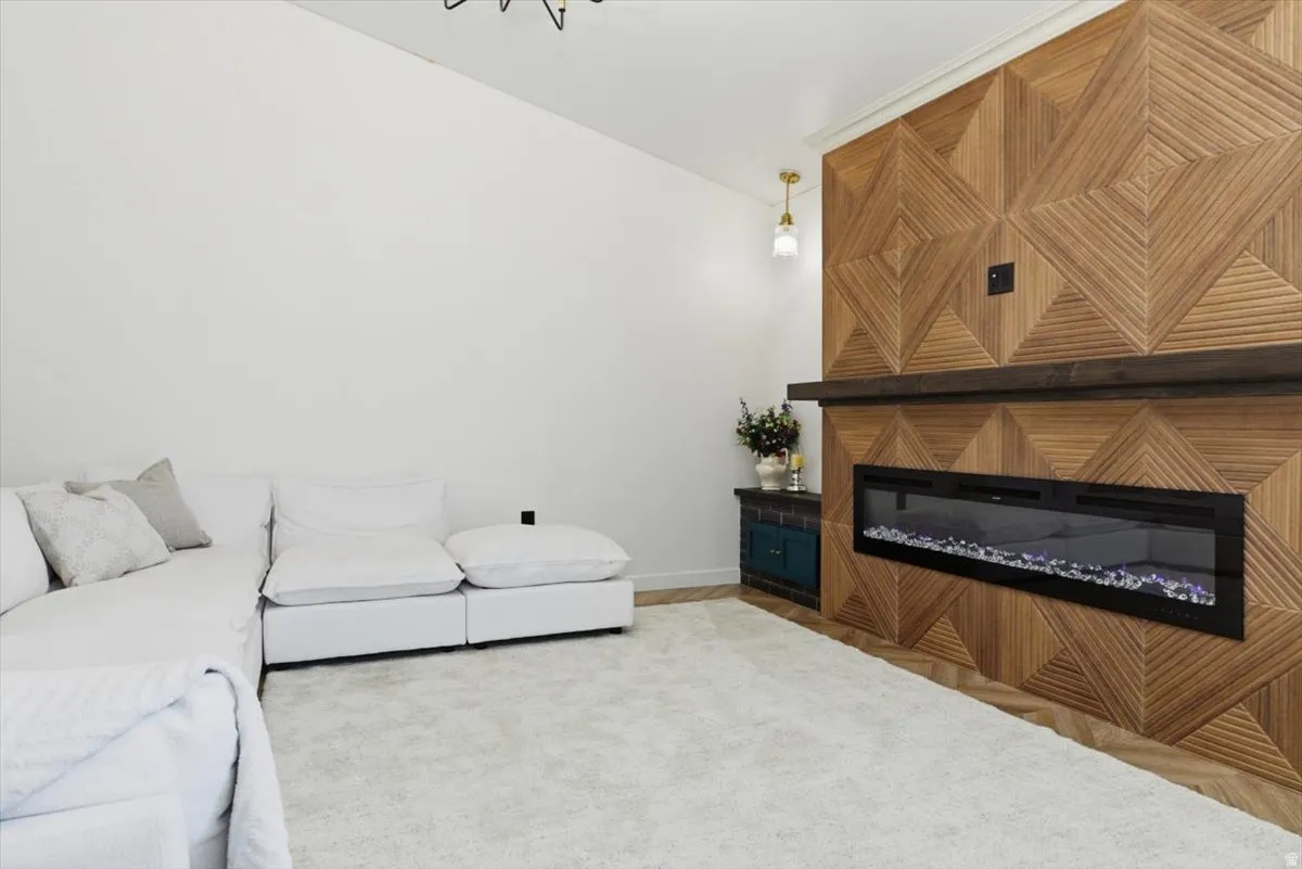 Feature wall with geometric wood paneling, linear electric fireplace, and dark wood mantel