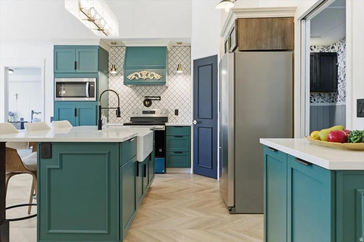 Kitchen featuring a central island with a farmhouse sink, white countertops, and teal cabinetry