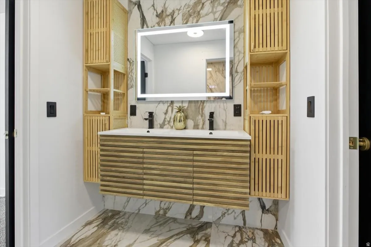 Contemporary bathroom featuring a floating dual-sink vanity with a slatted wood-finish facade