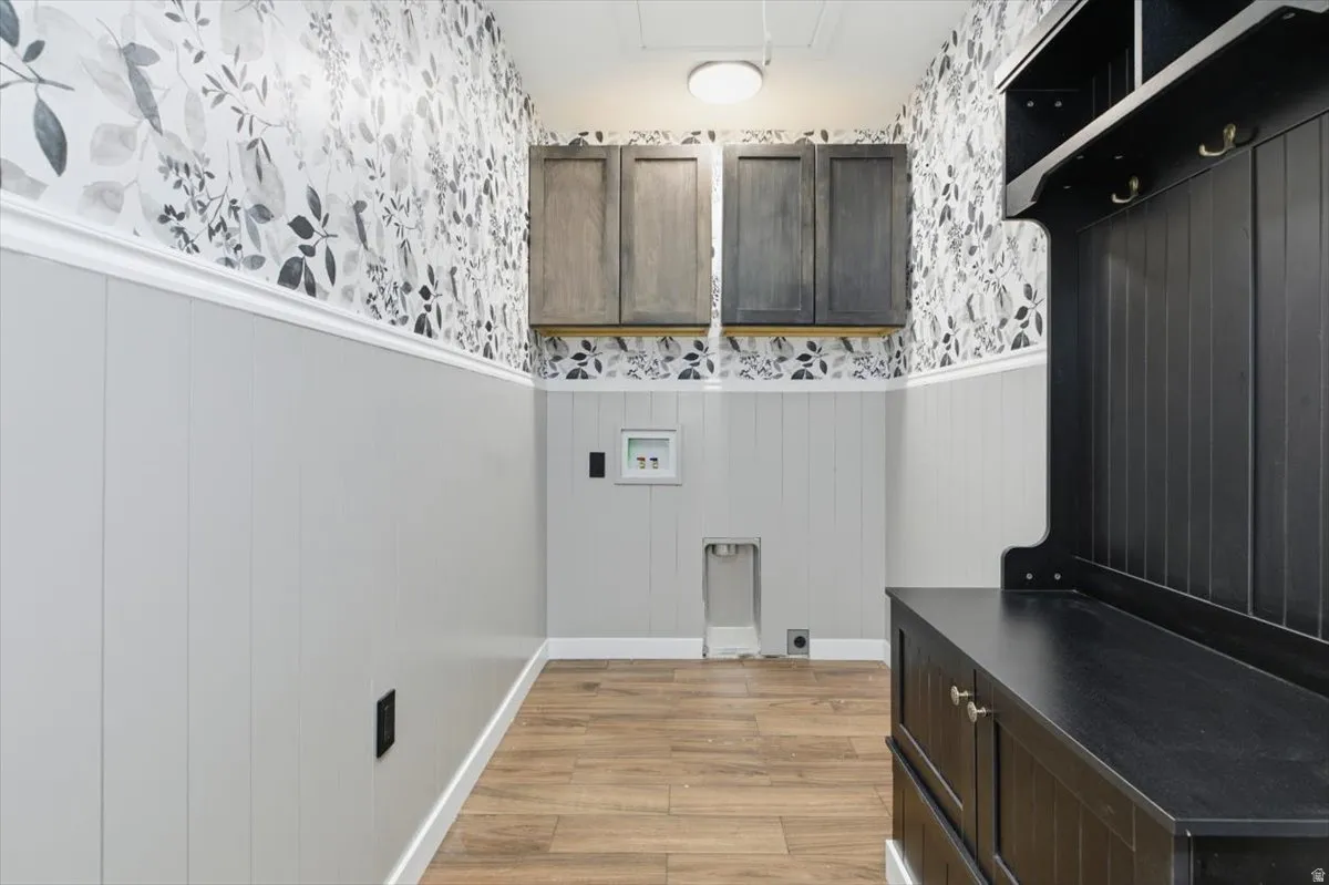 Dedicated utility space featuring wood-finish flooring and wainscoting