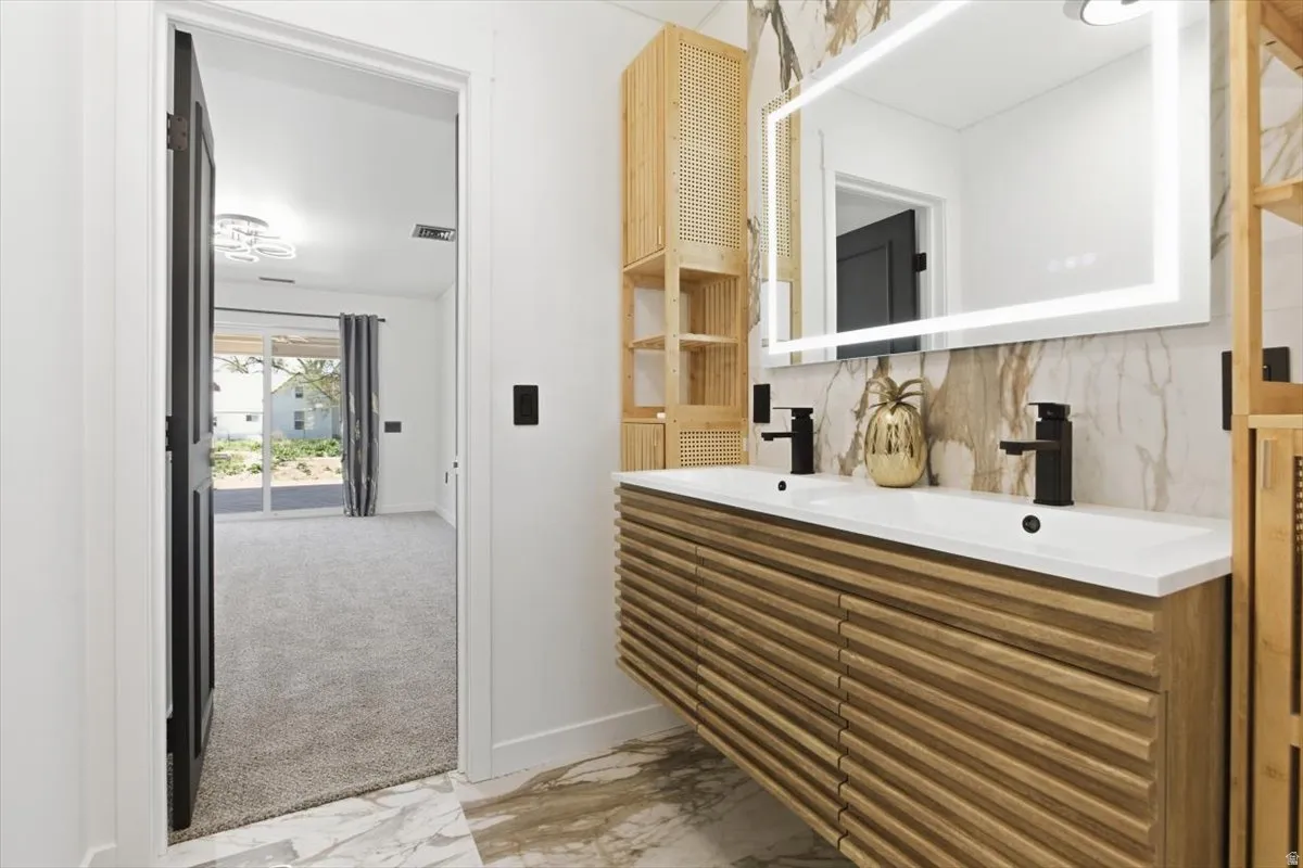 Double vanity featuring a fluted wood-finish base, dual integrated sinks, and matte black fixtures