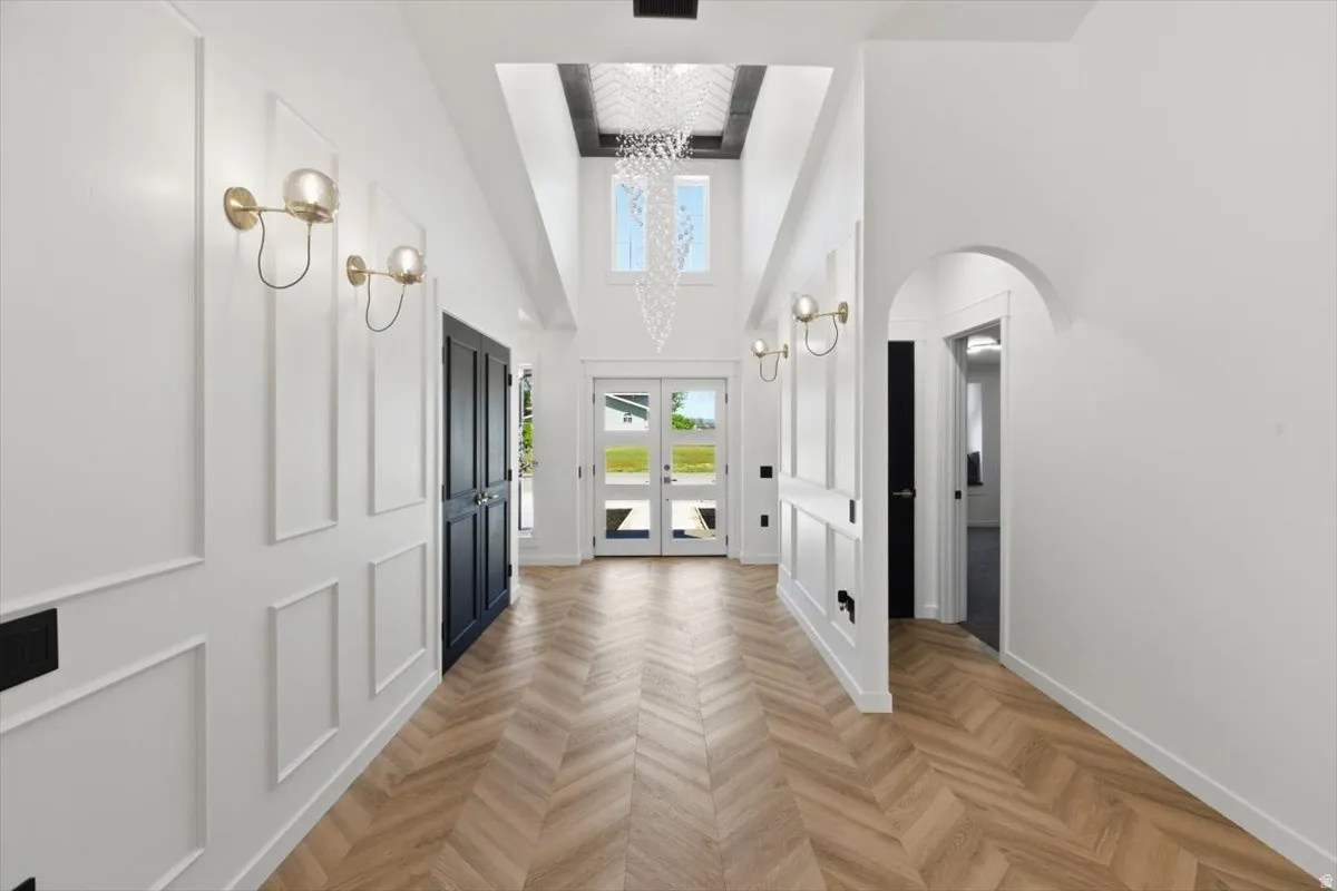 Two-story foyer with wood-finish flooring in a herringbone pattern