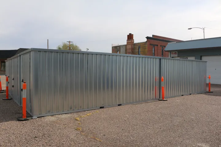 Corrugated metal fencing enclosing a gravel lot