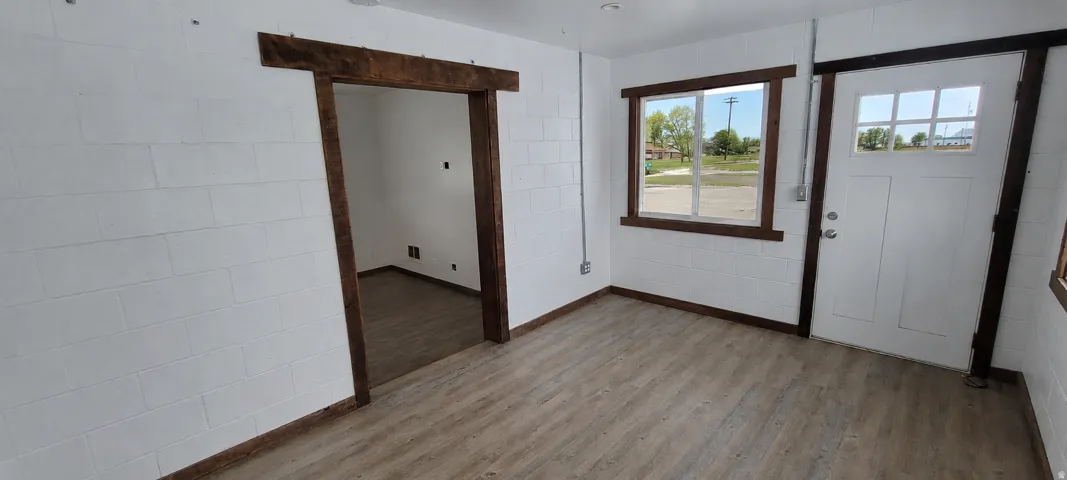 Light wood-finish flooring complemented by white block walls