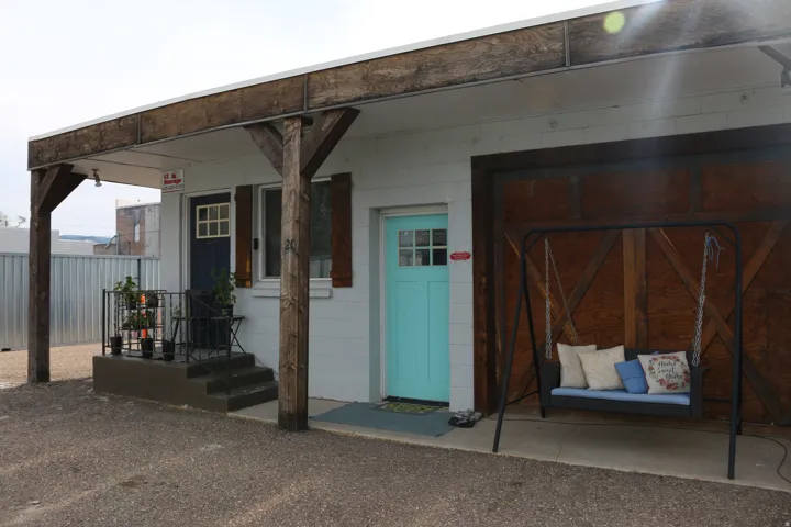 Facade featuring a covered porch with exposed timber beams and posts