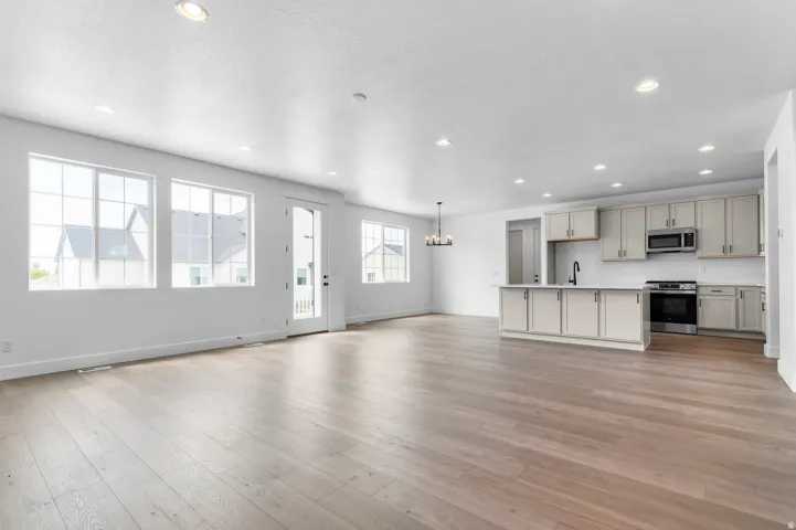 Open-concept living space featuring wood-finish flooring, recessed lighting, and ample natural light through multiple windows