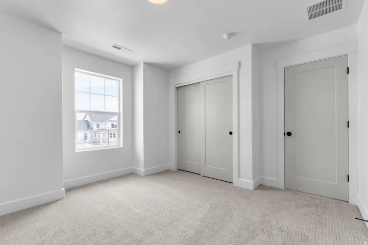Windowed room featuring light gray carpeting and white walls