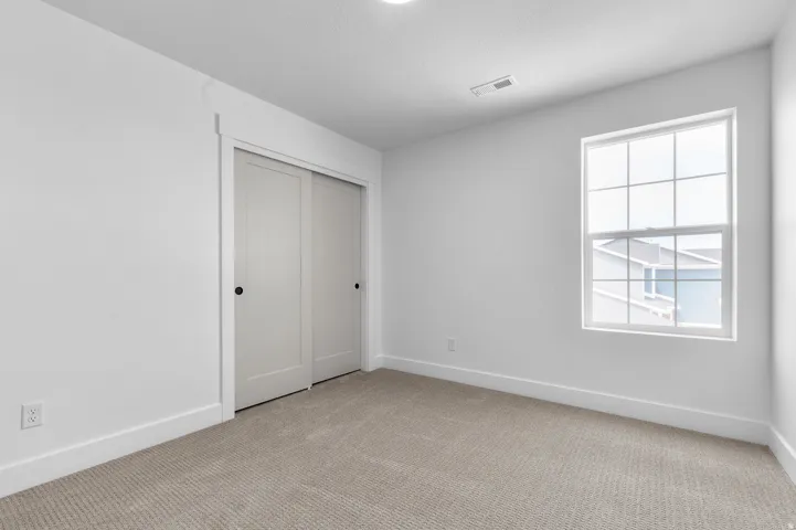 Room featuring neutral carpet, white walls, and a window with grid panes