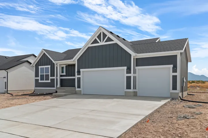 Contemporary exterior featuring dark gray vertical siding with white trim, a two-car garage, a single-car garage, concrete driveway, and a shingled roof