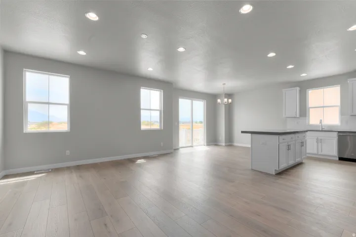 Open-concept interior featuring light wood-finish flooring, recessed lighting, and a neutral color palette