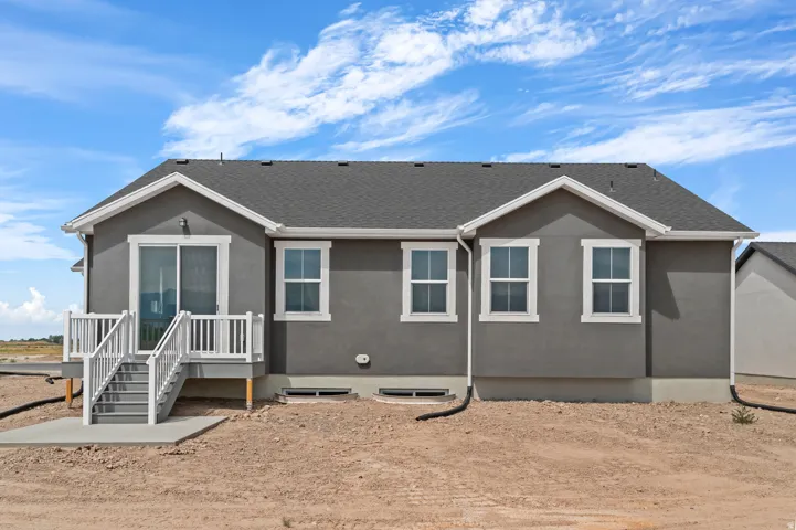Gray stucco exterior with white trim, featuring a dark gray shingle roof