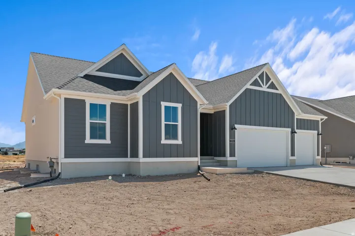 Contemporary ranch-style exterior featuring gray vertical siding, light stucco accents, and a dark shingle roof