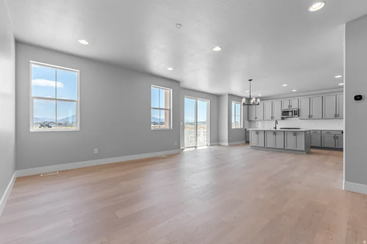 Open-concept living space featuring light wood-finish flooring, recessed lighting, and neutral wall tones