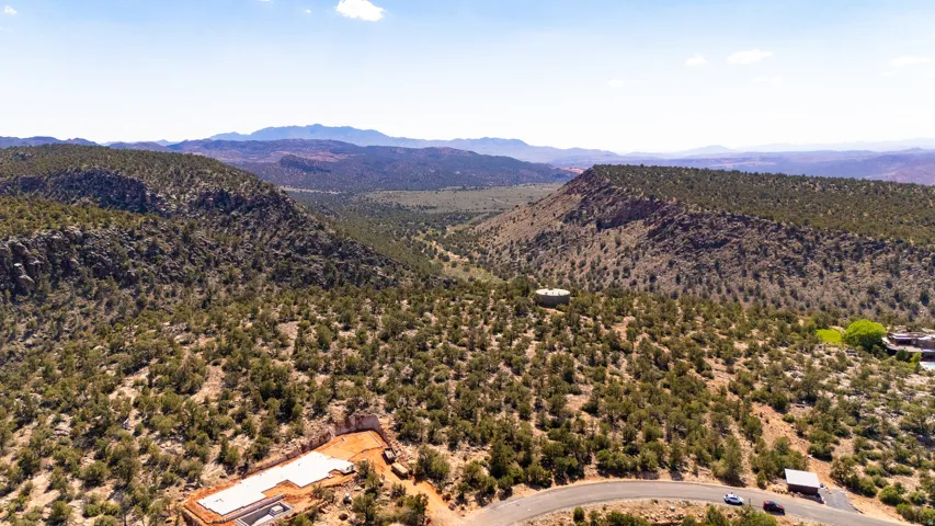 Expansive, undulating terrain featuring a cleared building site with a concrete foundation