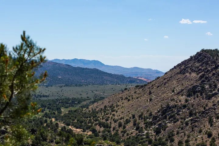 Expansive natural landscape featuring rolling hills and distant mountain ranges