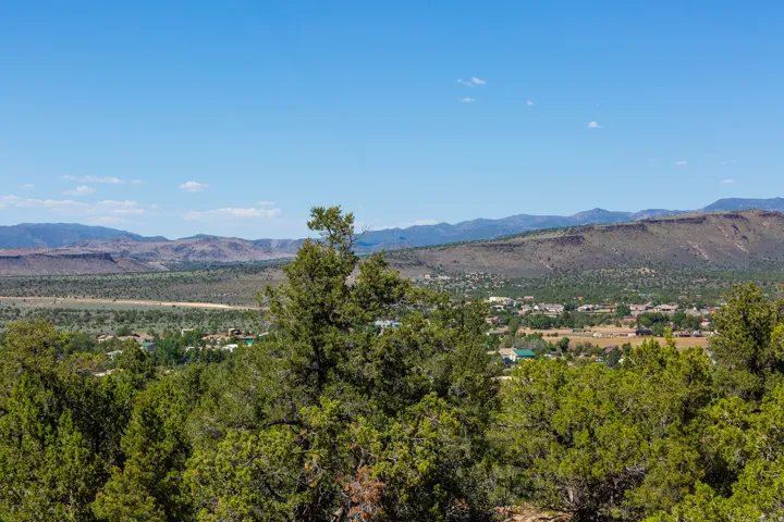 Expansive natural landscape featuring distant mountain formations and a community of structures