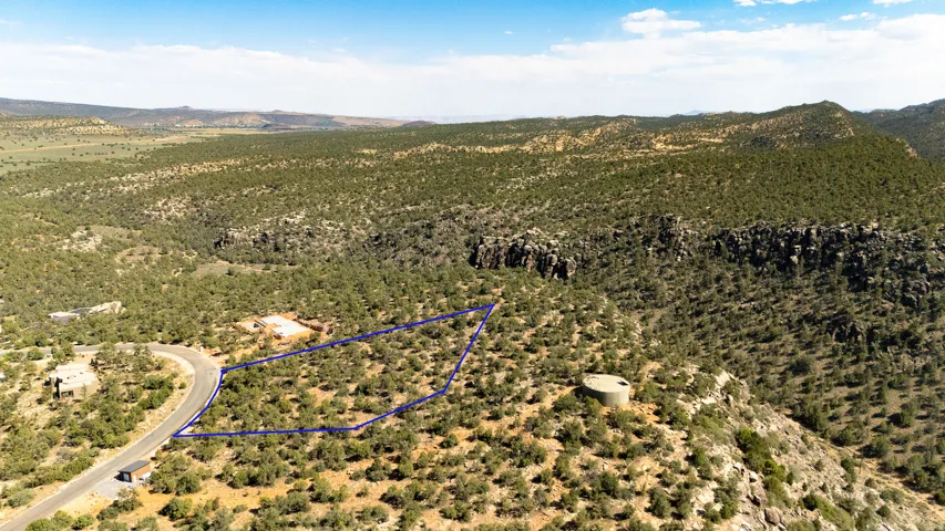 Expansive undeveloped lot featuring a natural, arid landscape with scattered low-lying vegetation