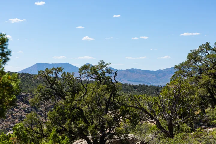 Expansive mountain landscape with a prominent distant peak under a clear blue sky