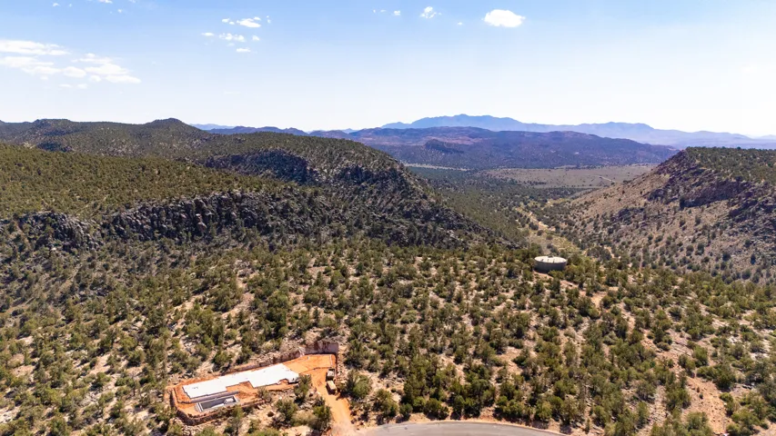 Expansive desert landscape featuring a partially constructed building foundation and surrounding mountainous terrain