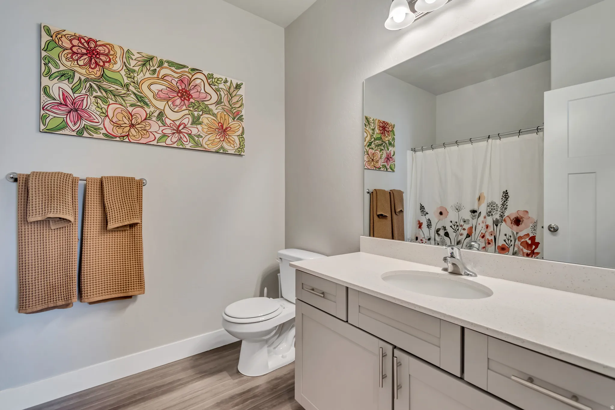 Full vanity featuring a single integrated sink, light-toned countertop, and light gray cabinetry with brushed nickel hardware