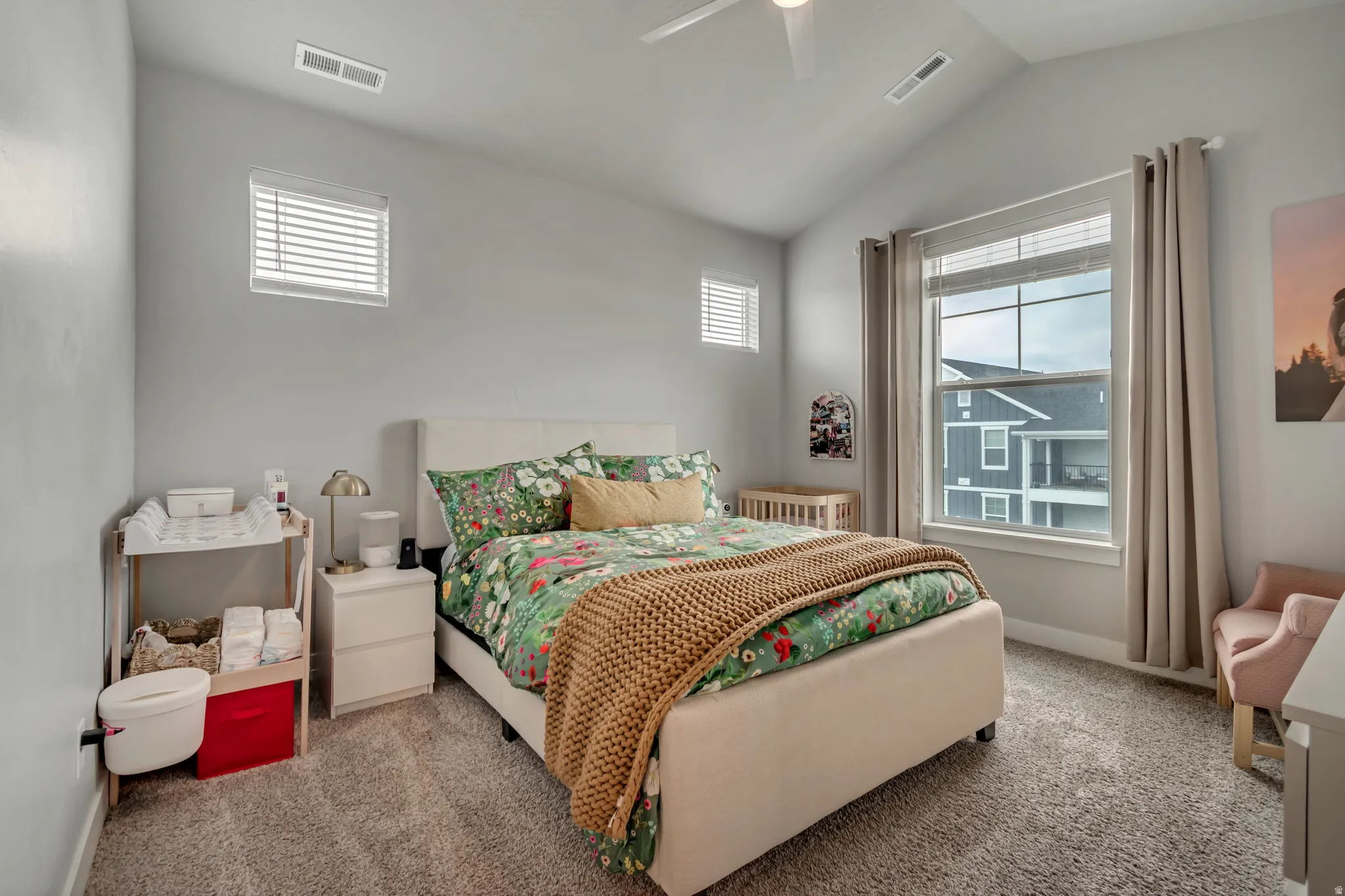 Carpeted bedroom with vaulted ceiling and a ceiling fan