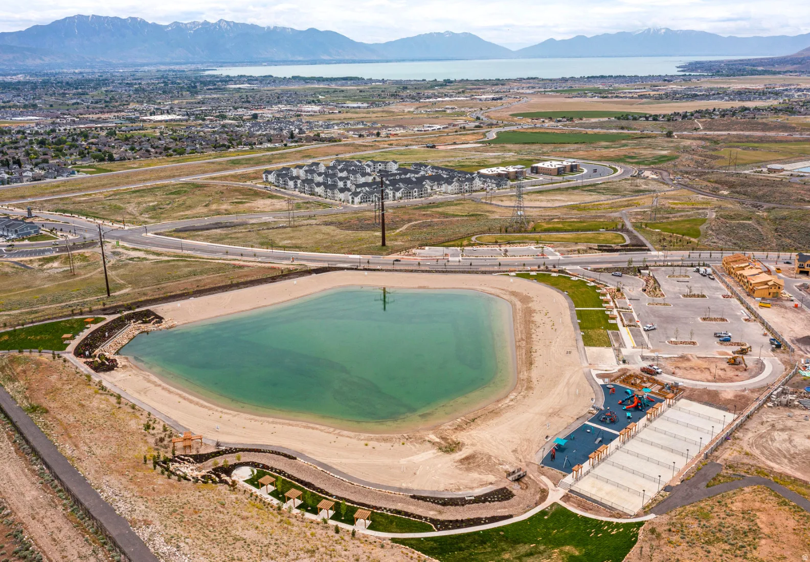 Expansive community lake with surrounding sandy beach