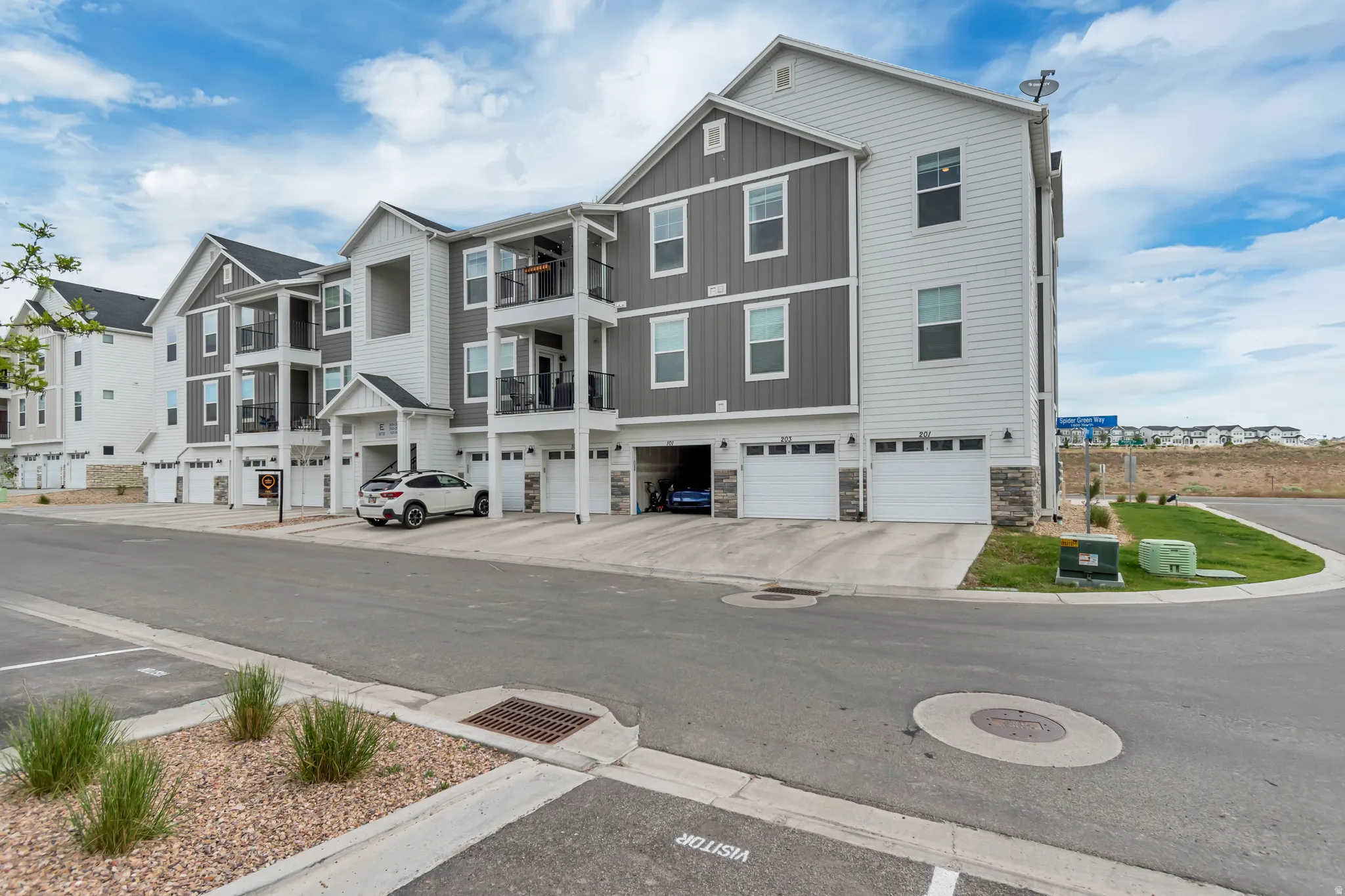 Contemporary multi-level townhome architecture featuring varied siding textures and stone accents