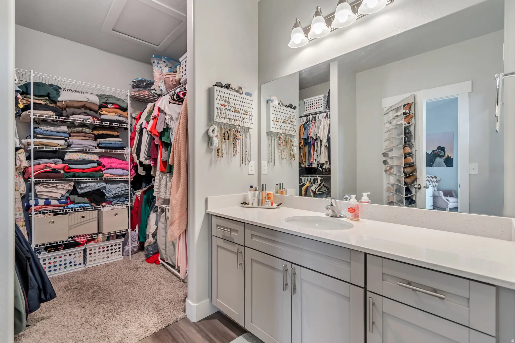 Vanity area featuring a single basin sink, white countertop, and light gray cabinetry with brushed nickel hardware