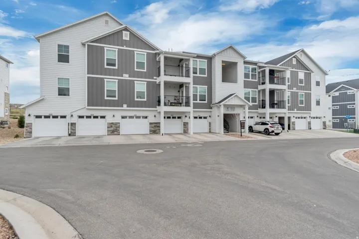 Modern multi-story building featuring white horizontal siding and gray vertical siding accents