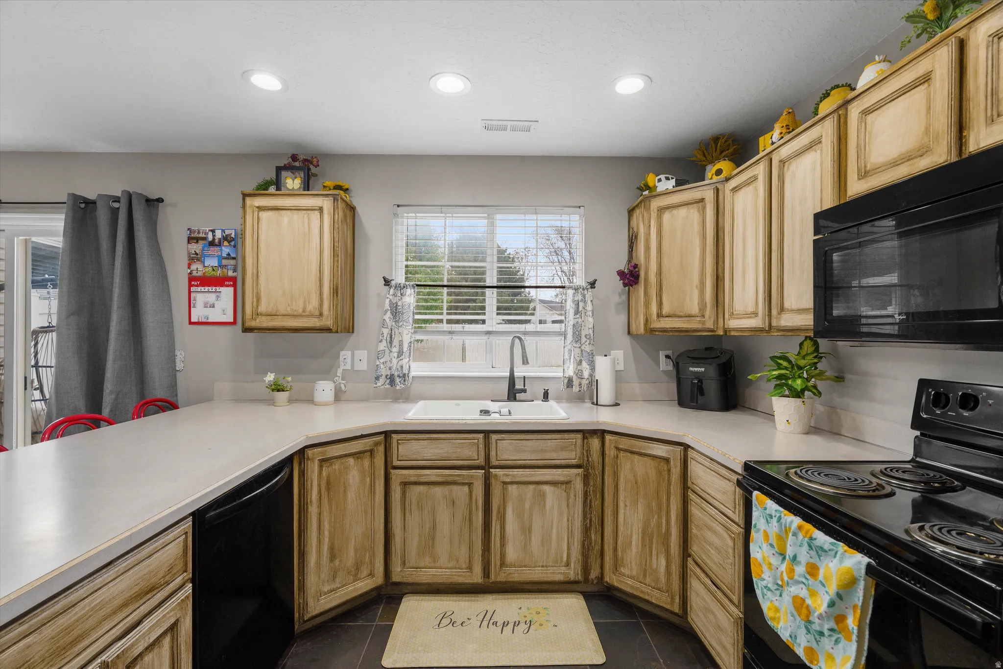 Kitchen featuring wood-finish cabinetry, black appliances, and recessed lighting