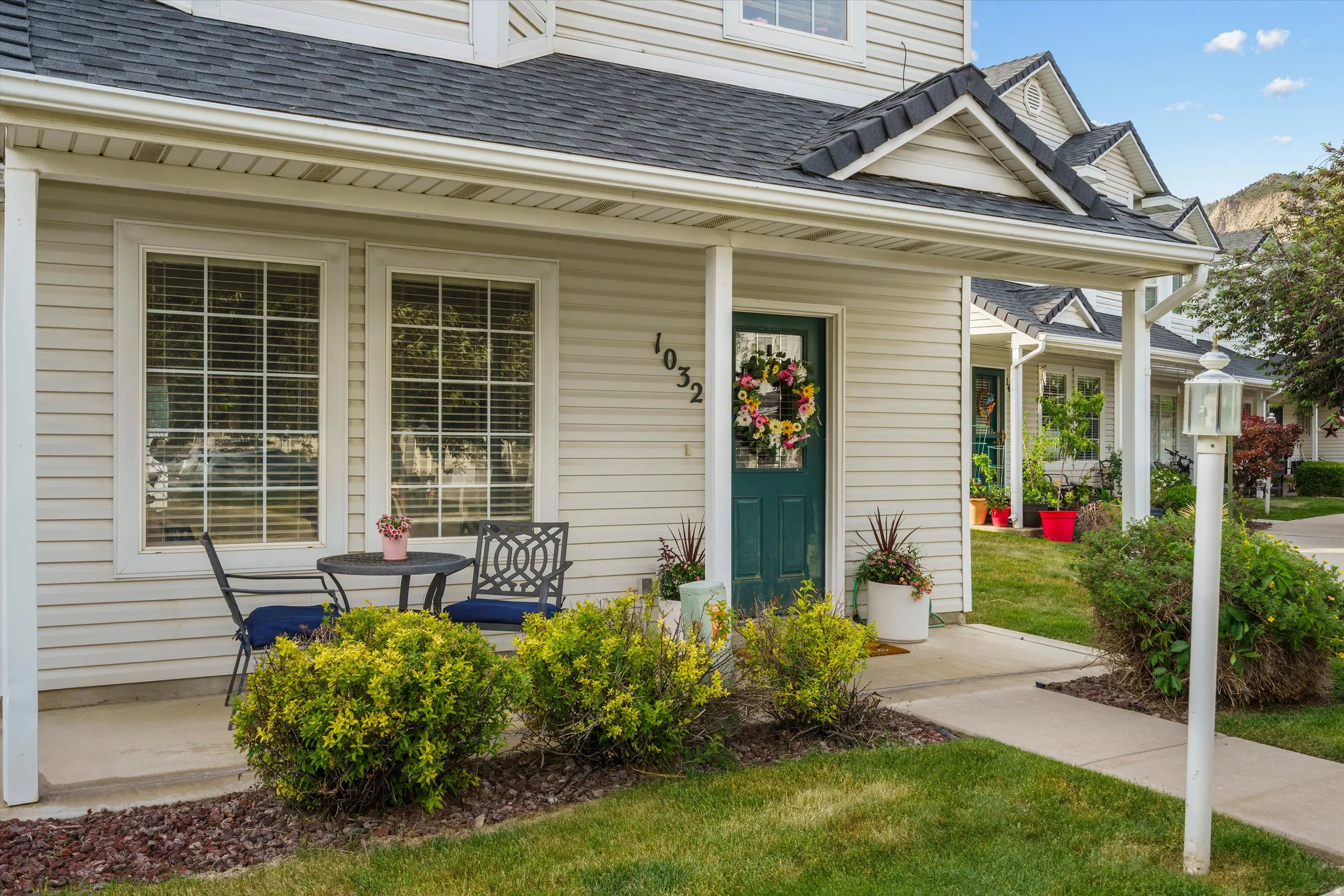 Inviting front facade featuring light-colored siding and a dark green entry door