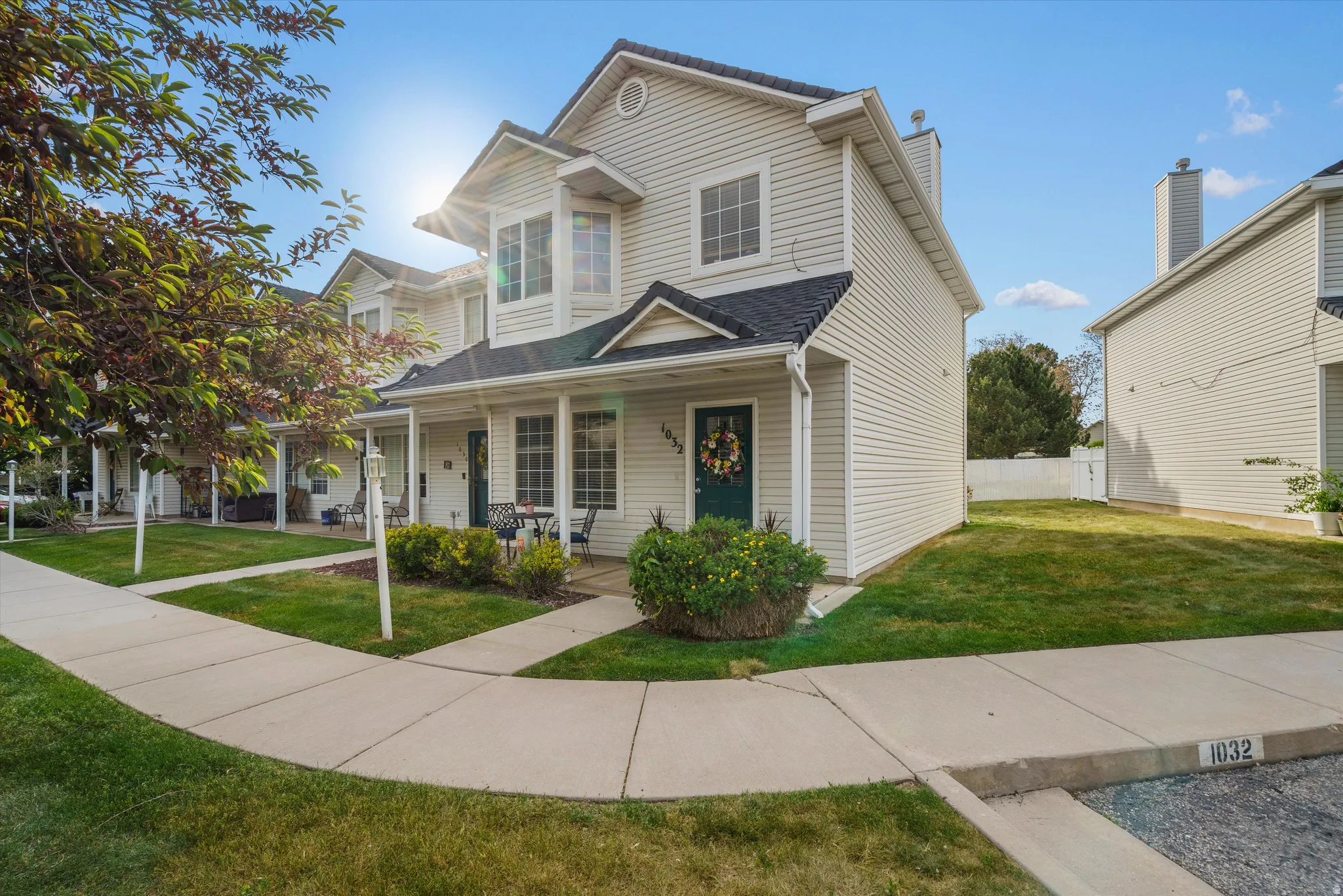 Two-story townhome featuring light-colored siding and dark shingle roofing