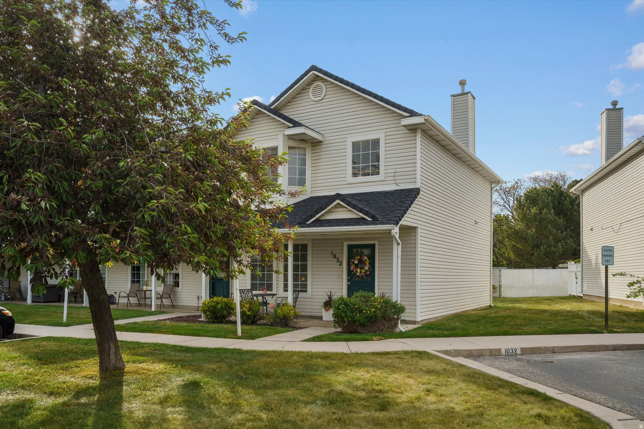 Two-story townhome featuring light-colored siding and a dark shingle roof