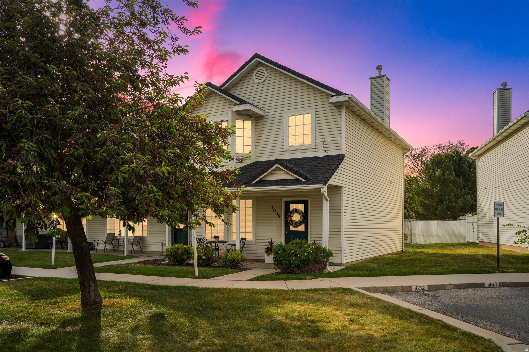 Two-story residence featuring light-colored siding,  and a dark shingle roof
