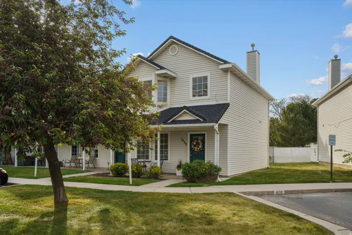 Two-story townhome featuring light-colored siding and a dark shingle roof
