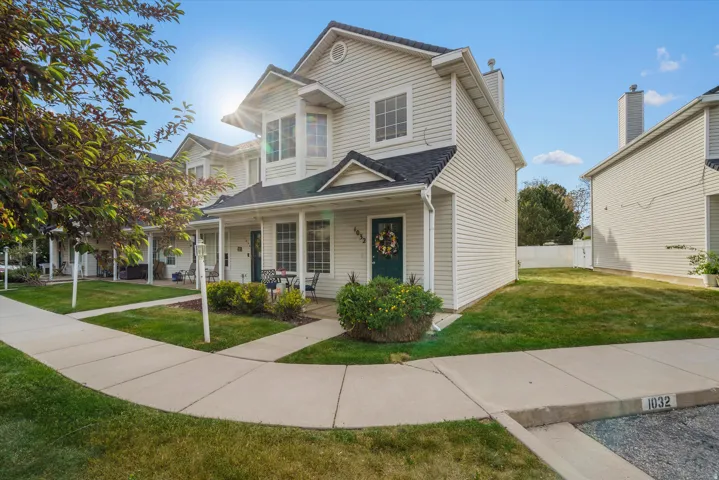 Two-story townhome featuring light-colored siding and dark shingle roofing