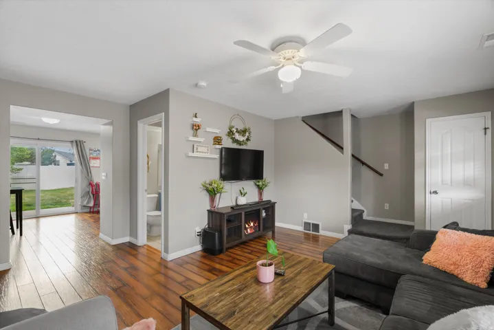 Living area featuring laminate flooring, a ceiling fan with integrated lighting