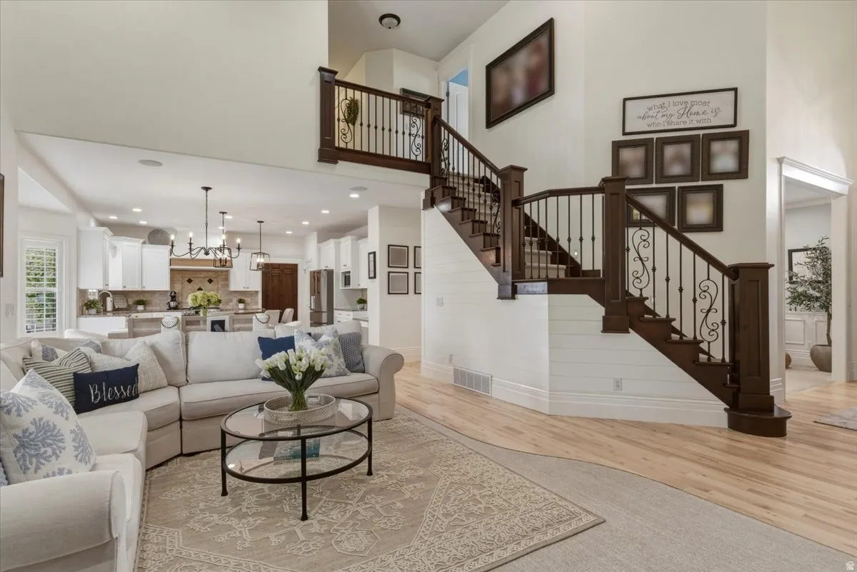 Grand entryway featuring a dark wood staircase with wrought iron balusters and light wood-finish flooring