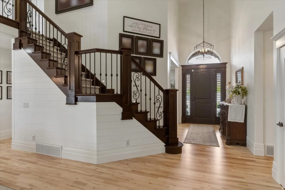 Grand entryway featuring a dark wood front door with sidelights, a transom window, and a geometric chandelier