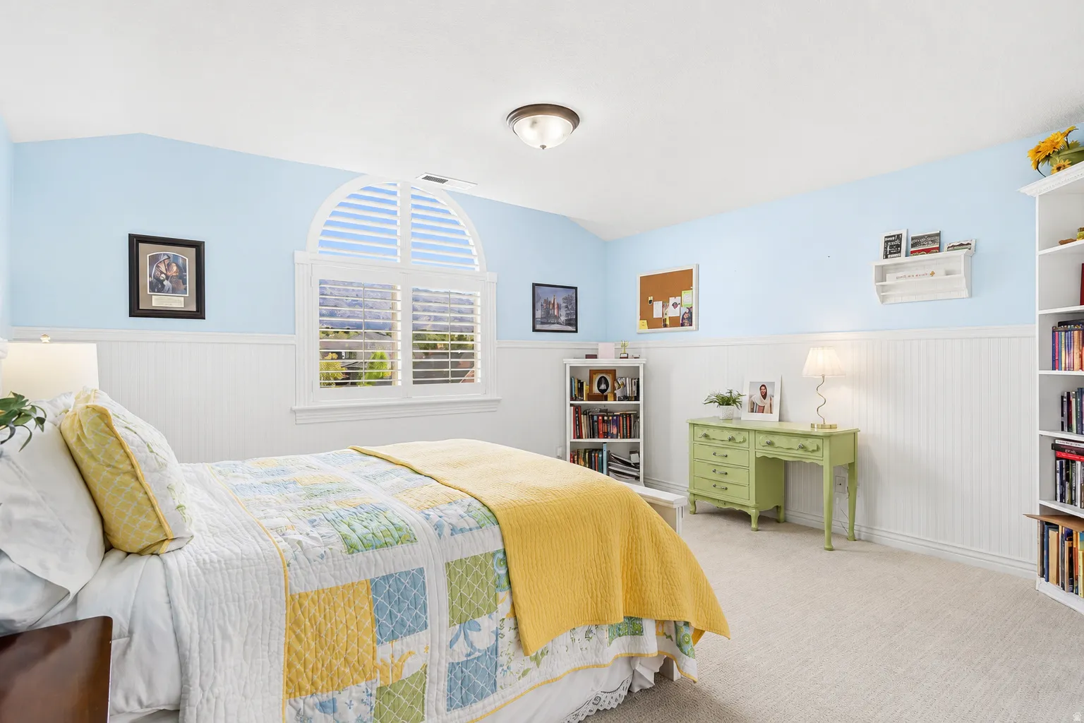 Spacious room featuring an arched window with integrated plantation shutters
